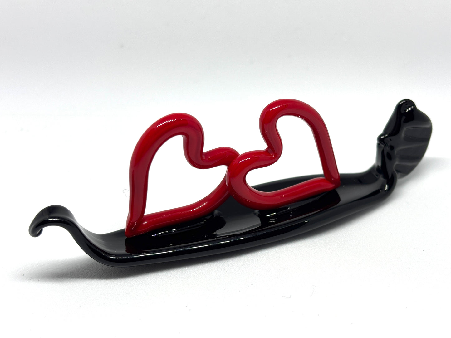 Due cuoricini rossi sopra una gondola veneziana. In vetro di Murano lavorato a lume.