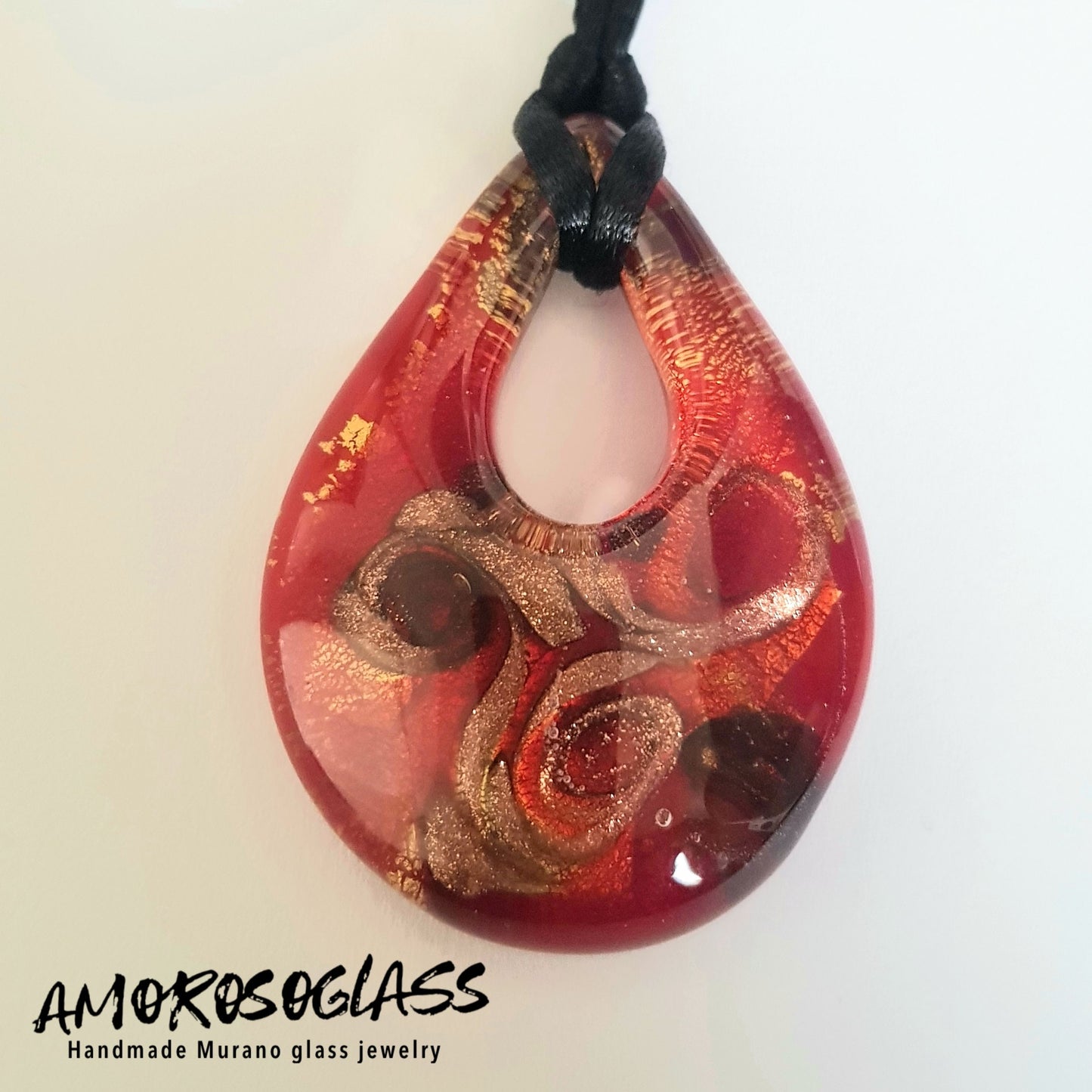 Pendente GOCCIA in vetro di Murano lavorato a lume con foglia Oro 24kt, vortici di avventurina e venature rosso trasparente, fondo rosso.