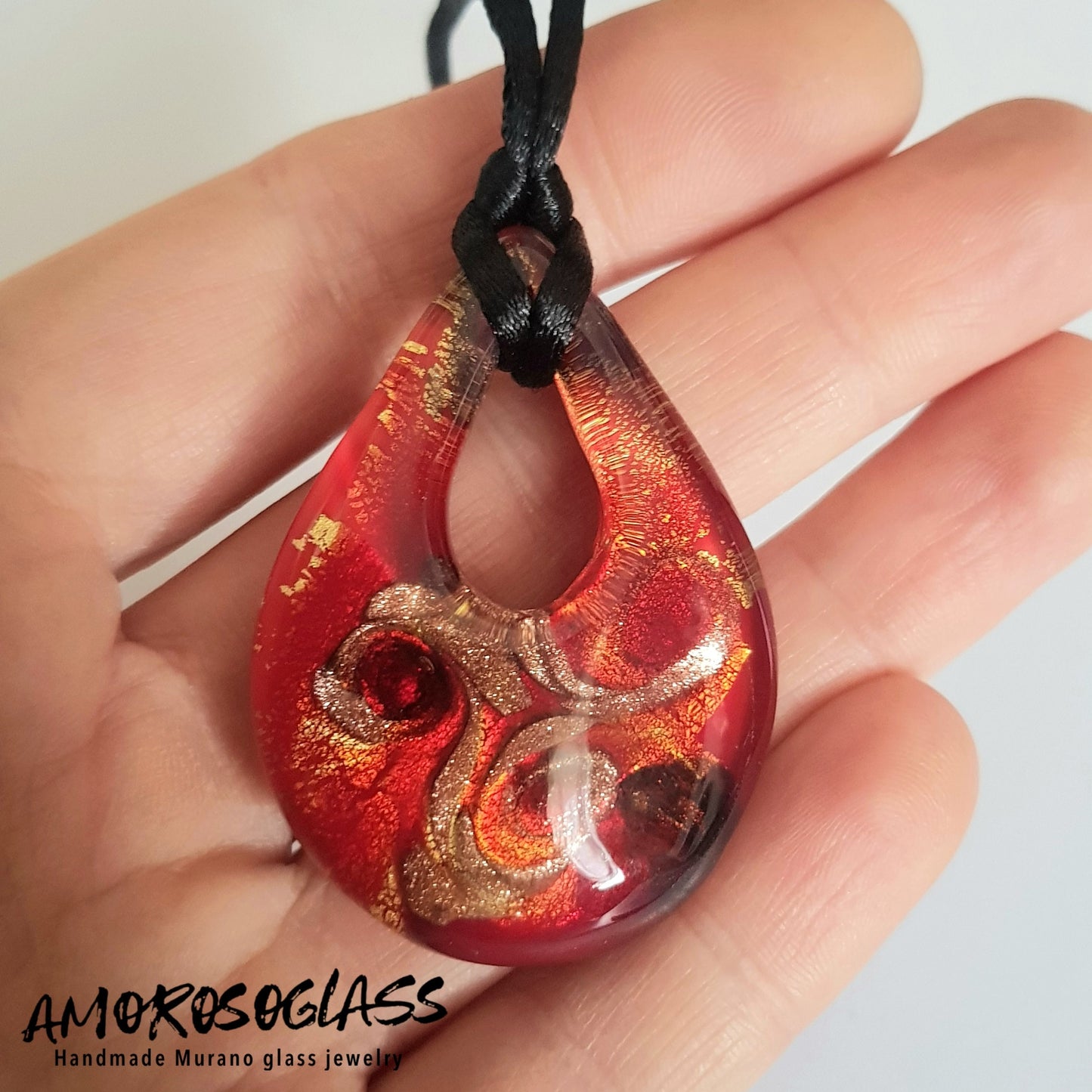Pendente GOCCIA in vetro di Murano lavorato a lume con foglia Oro 24kt, vortici di avventurina e venature rosso trasparente, fondo rosso.