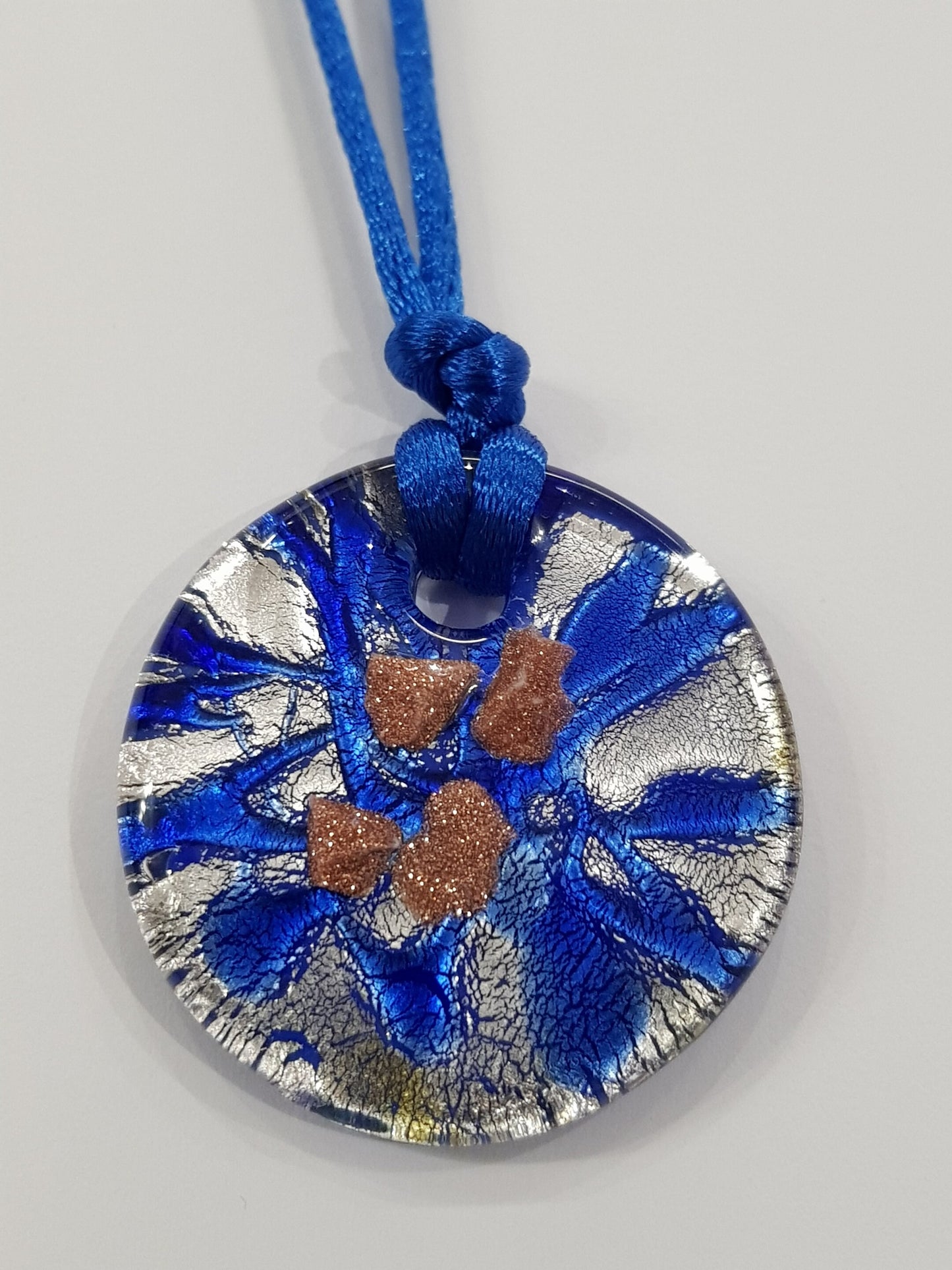 Pendente dischetto in vetro di Murano lavorato a lume con foglia argento e avventurina.