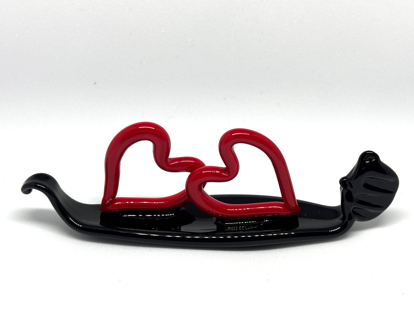 Due cuoricini rossi sopra una gondola veneziana. In vetro di Murano lavorato a lume.