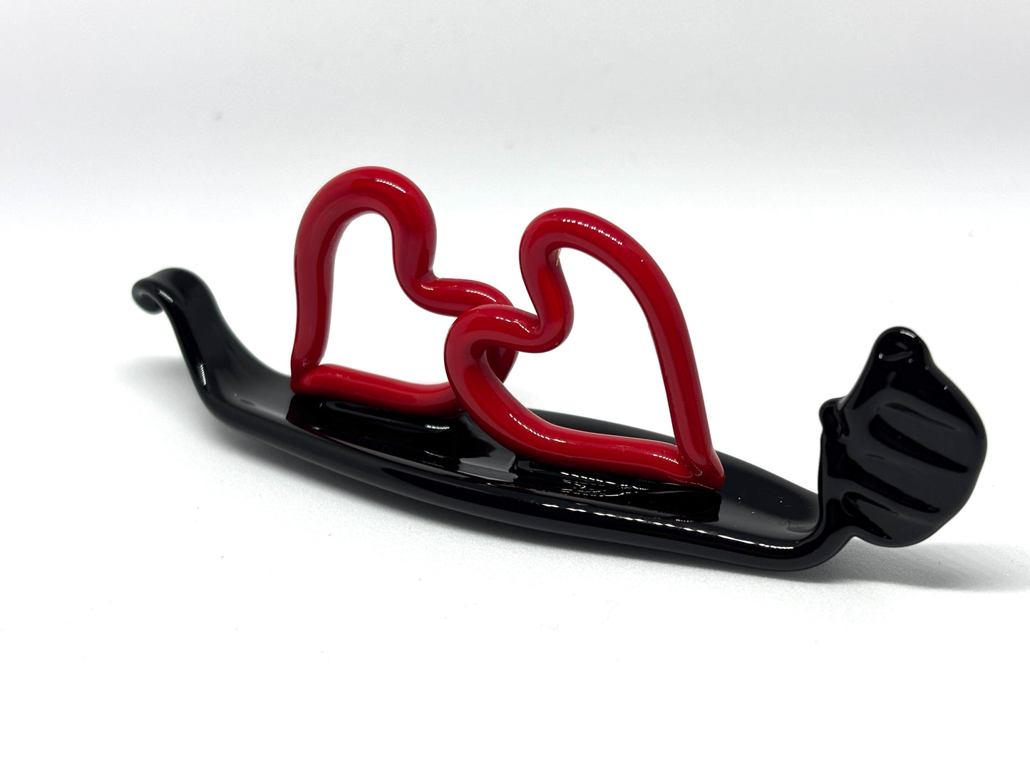 Due cuoricini rossi sopra una gondola veneziana. In vetro di Murano lavorato a lume.