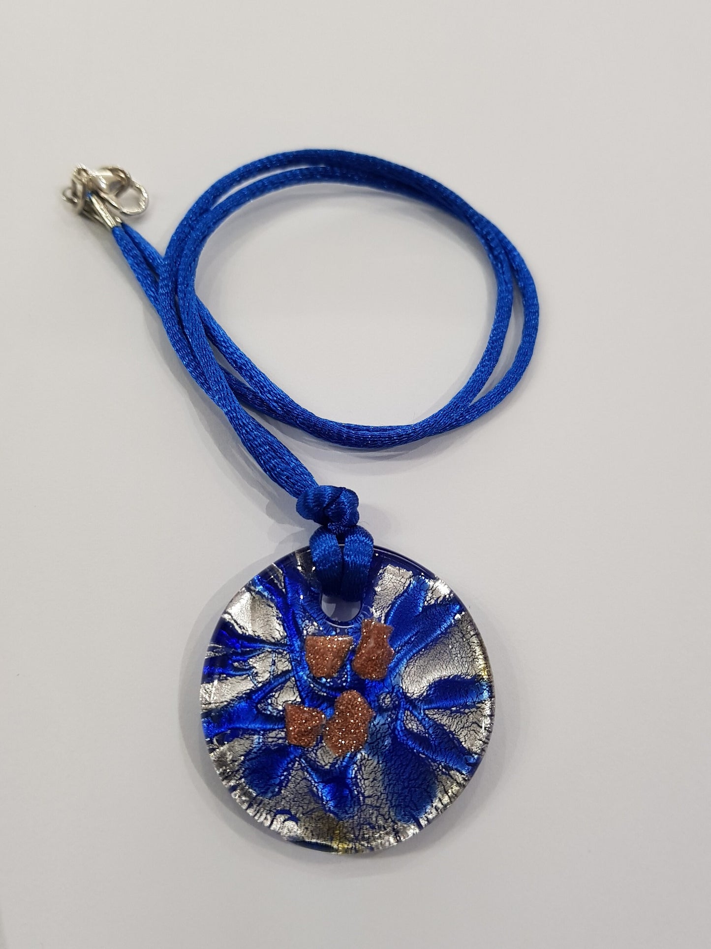 Pendente dischetto in vetro di Murano lavorato a lume con foglia argento e avventurina.